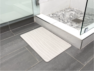 Person placing a stone bath mat outside their shower.